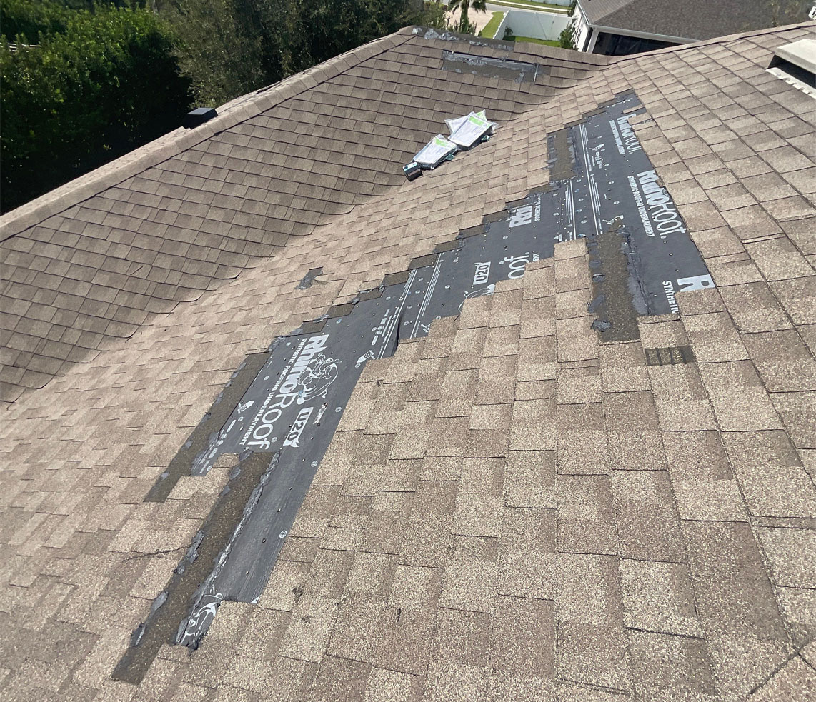 An asphalt shingle roof undergoing repairs